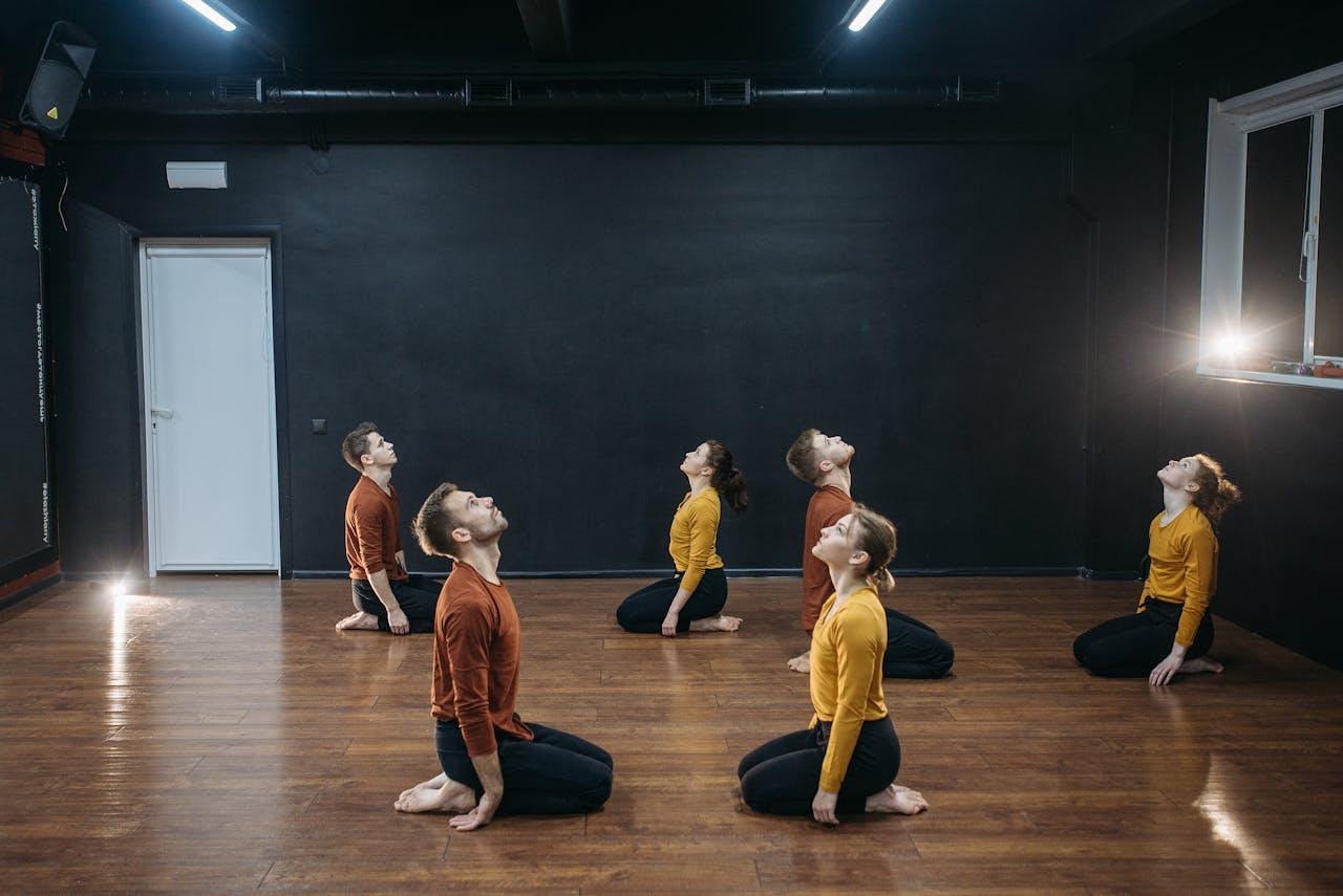 The Art of Drawing Readers In: Your attractive post title goes here A group of adults rehearsing a contemporary dance routine in a minimalist studio setting.