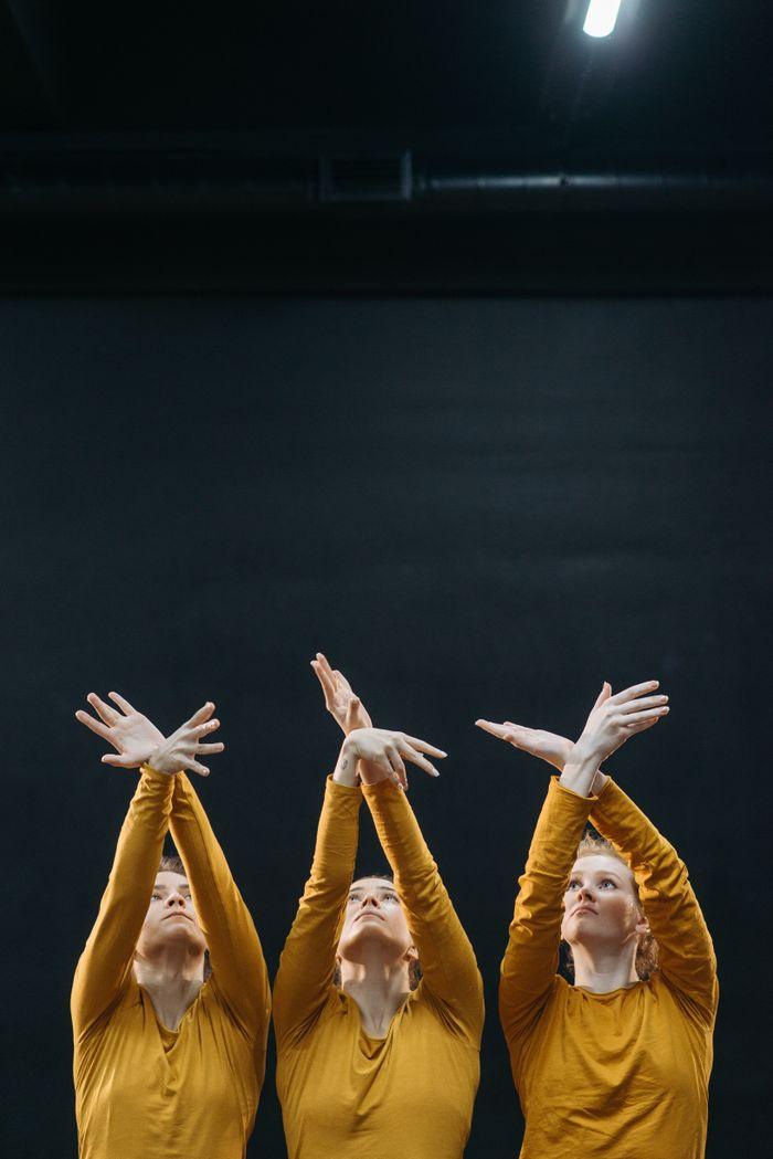 Crafting Captivating Headlines: Your awesome post title goes here Three dancers in synchronized motion, expressing grace and creativity indoors.